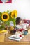 The little girl is having breakfast at home. On the table is a bouquet of flowers of sunflowers and a sweet pie with fruit,
