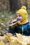 Little girl having fun autumn forest. Kid sitting yellow leaves
