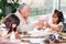 Little girl having fun with her sister and their grandmother while making christmas Nativity crafts