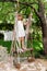 Little girl having fun on a swing outdoor. Child playing, garden playground.