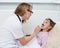 Little girl having his throat examined by health professional