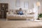 Little girl with headphones meditating on sofa at home