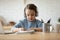 Little girl in headphones writing in notebook