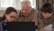 Little girl help her grandpa to type on laptop