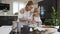 Little girl helping her mom in the kitchen by stirring the ingredients for their cake with a spoon. Little cute girl