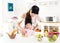 Little girl helping her mother prepare food in the kitchen