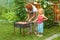 Little girl helping her mother to cook shish kebab