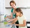 Little girl helping mother at kitchen