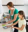 Little girl helping mother at kitchen