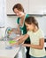 Little girl helping mother at kitchen