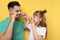 Little girl and her father flossing teeth