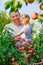 Little girl with her father picking peaches