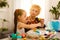 Little girl and her grandmother painting Easter eggs at home.