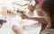 Little girl and her grandmother painting together at table, closeup view