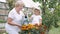 Little girl and her grandmother watering flowers in garden