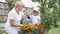 Little girl and her grandmother watering flowers in garden