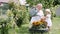 Little girl and her grandmother watering flowers in garden