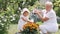 Little girl and her grandmother watering flowers in garden