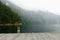 A little girl with her life jacket on standing on a dock admiring the view of the misty princess louisa inlet