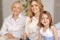 Little girl, her mother and grandmother posing for camera