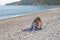 A little girl with her mother looks at the pebbles on the shore