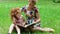 Little girl and her mother read book on grass