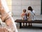 A little girl and her mother are sitted on a street bench