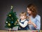 Little girl and her mummy decorates the Christmas tree