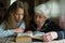 Little girl with her old grandma reading a book