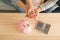 Little girl and her parents with coins and piggy bank at home. Money savings concept