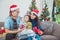 Little girl and her parents open christmas gift boxes