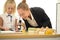 A little girl and her teacher study biology using a microscope in the school science lab.