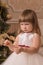 Little girl hesitates to keep a New Year`s toy in her hands