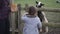 Little girl hesitating to hand feed a black and white sheep behind a fence
