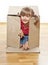 Little girl hiding inside paper box