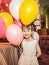Little girl holding balloons. The child smiles cheerfully on a holiday.