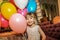 Little girl holding balloons. The child smiles cheerfully on a holiday.