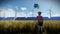 Little Girl holding Balloons on wheat field with Wind Turbines and Solar Panel Farm, 4K