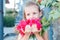 Little girl is holding beautiful pink flowers. bougainvillea