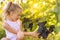 Little girl holding bunch of grapes, sunset background