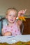 little girl holding a figurine made of plasticine and autumn leaves in her hands