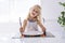 Little girl holding fork empty plate ready for food.