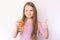 Little girl holding a fumigator from mosquitoes and the hand that shows the class, on a light background