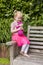 Little Girl Holding Homemade Crochet Doll In The Garden