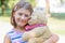 Little girl  holding large teddy bear outside