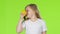 Little girl is holding a lemon and sniffing it. Green Screen