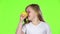Little girl is holding a lemon and sniffing it. Green screen. Slow motion