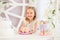 Little girl holding a pink plate with sweet cakes in the candy bar