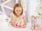 Little girl holding a pink plate with sweet cakes in the candy bar