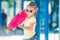 Little girl holding pink skateboard at the playground